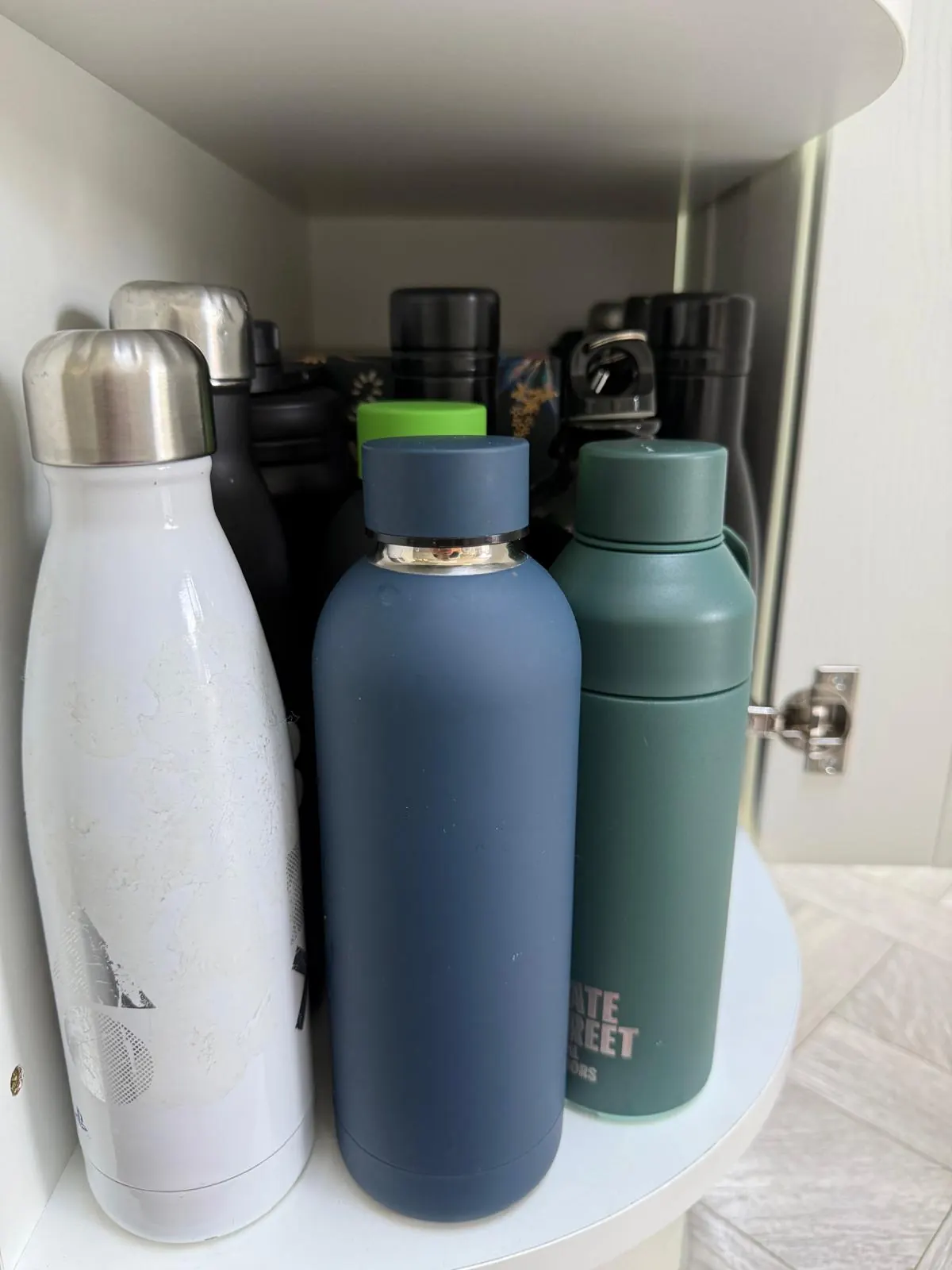 Organised cupboard turntable holding reusable water bottles