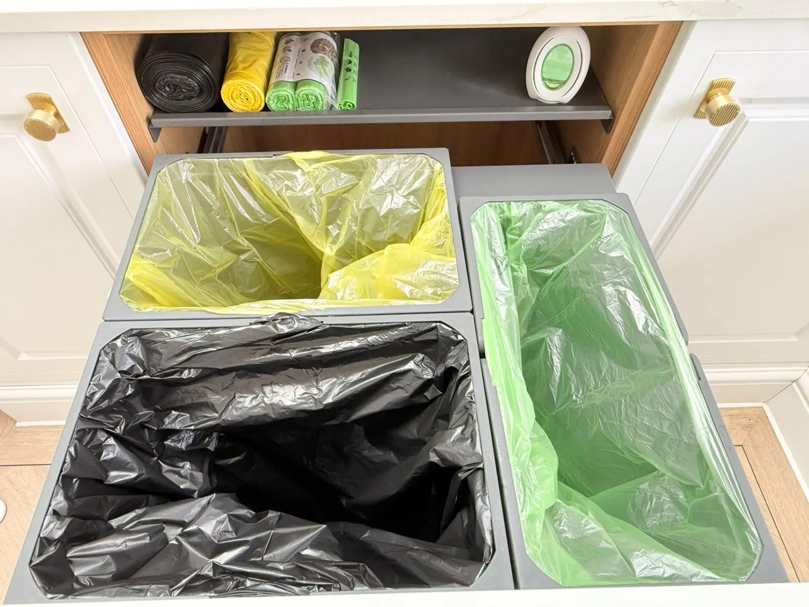 Kitchen bin cupboard after organising, with lined, separated waste and recycling bins
