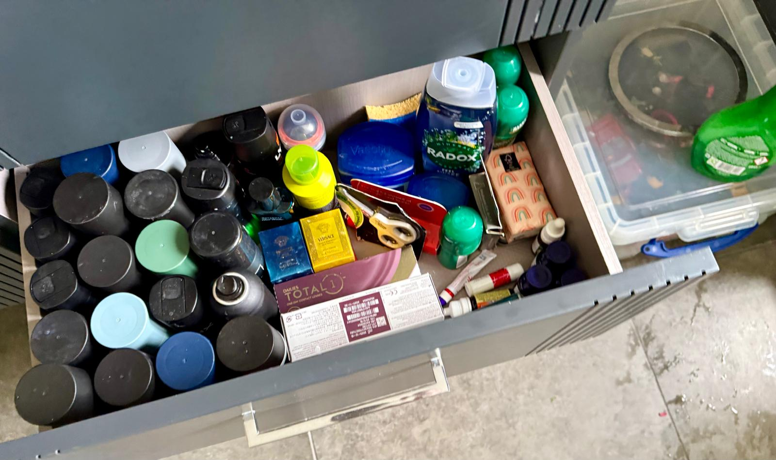 Bathroom drawer before organising, filled with toiletries and skincare products