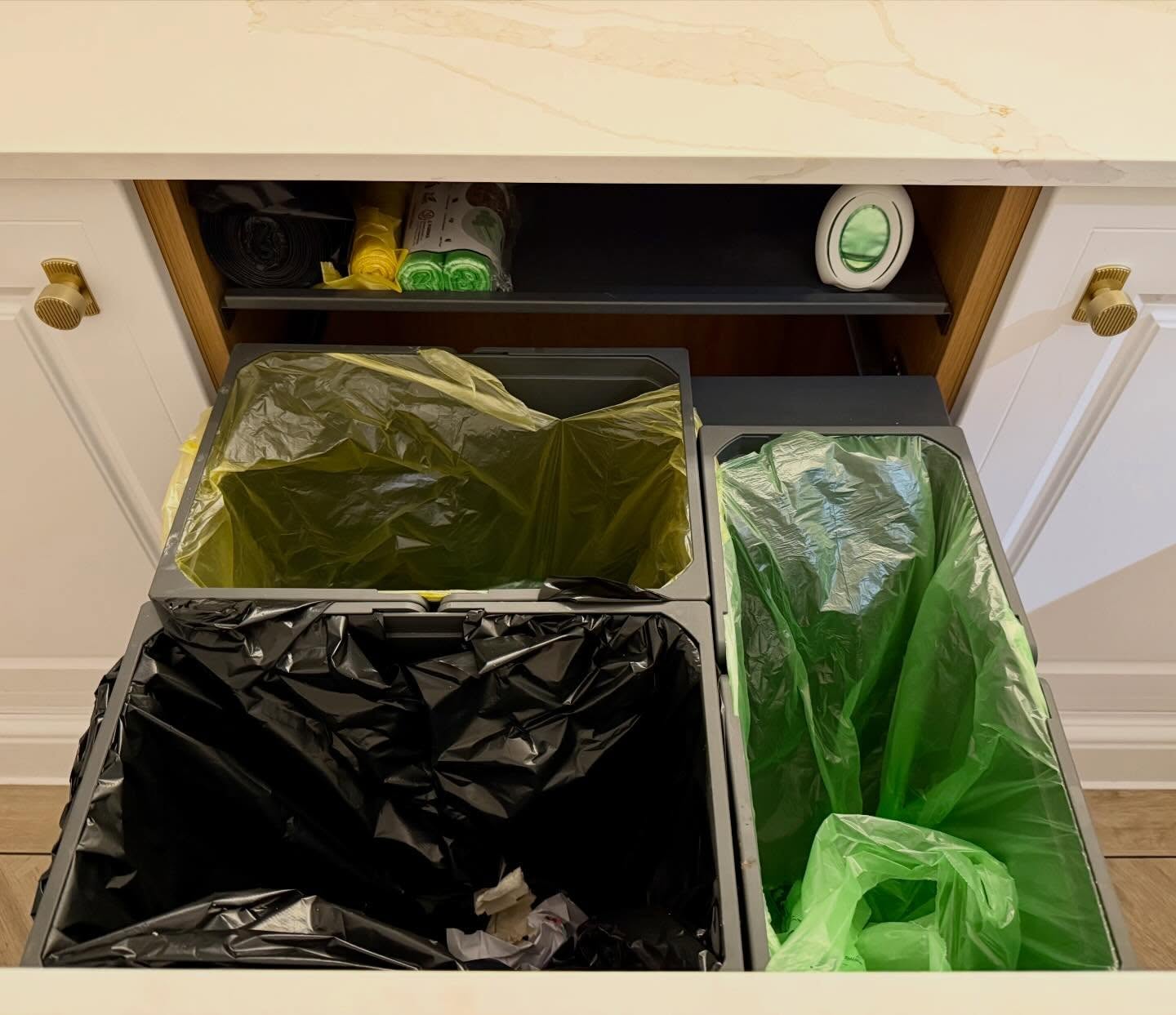 Kitchen bin cupboard after organising, with lined, separated waste and recycling bins